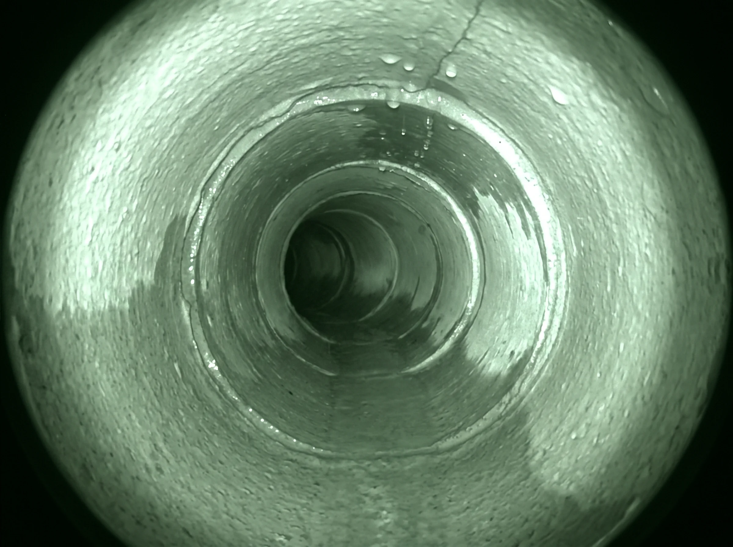 CCTV camera view down a clean clay drain pipe at the start of a survey run